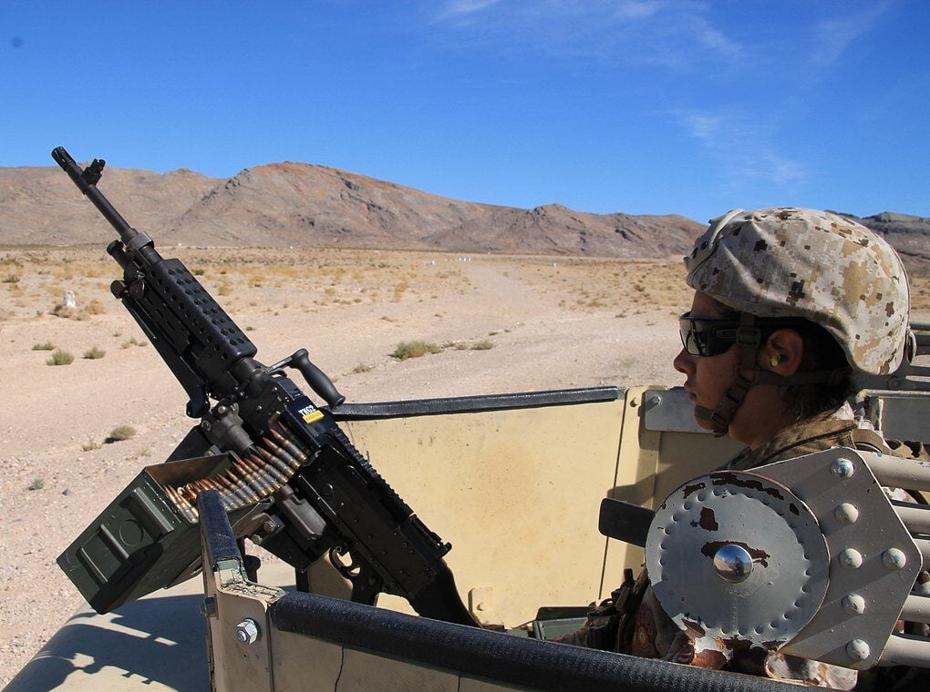 female soldier with machine gun in desert