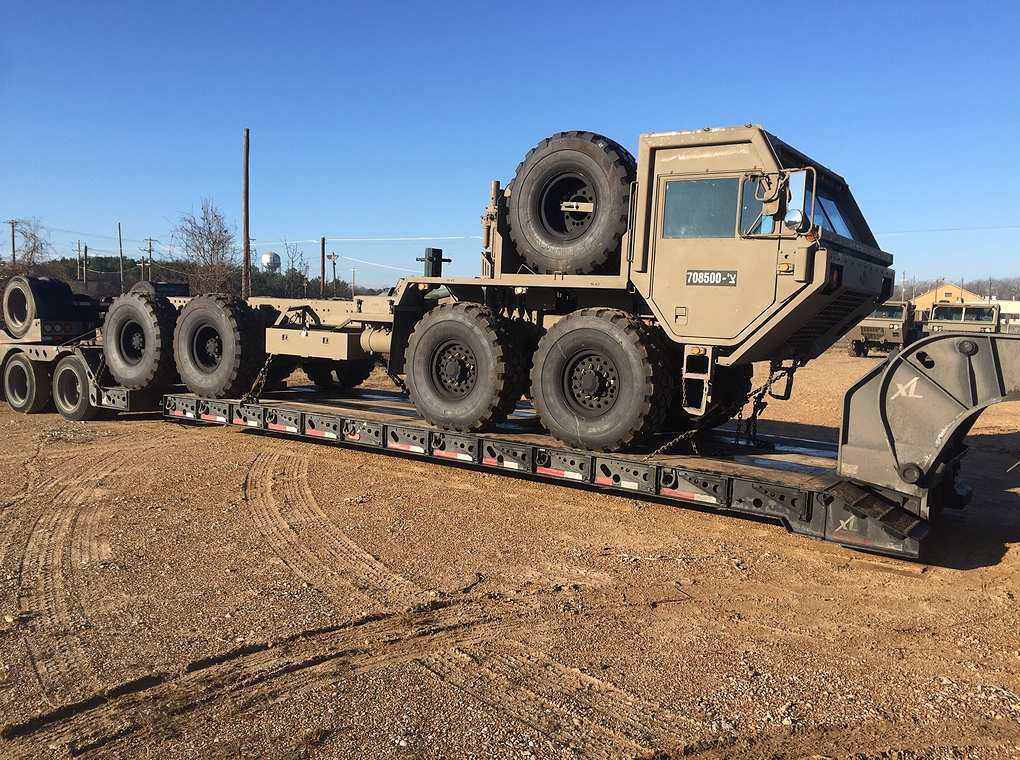 tactical vehicle on top of flatbed trailer outdoors