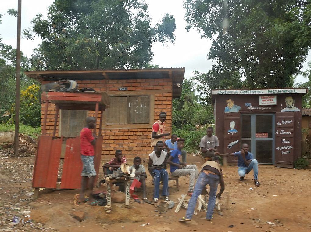 group of young people gathered outside two small buildings