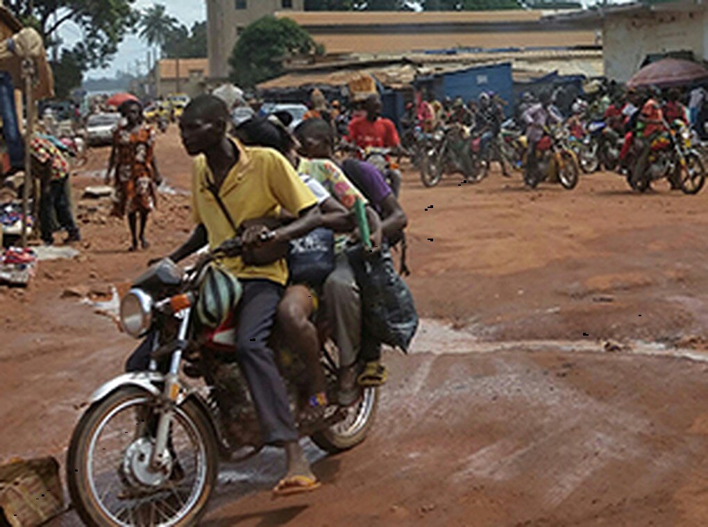 people riding motorbikes through village