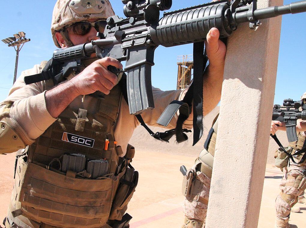 soldier aiming assault rifle in desert