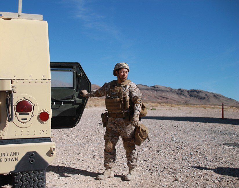 female soldier by Humvee