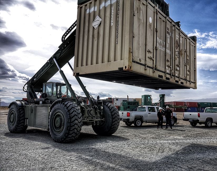 Heavy duty front end loader holding a cargo container